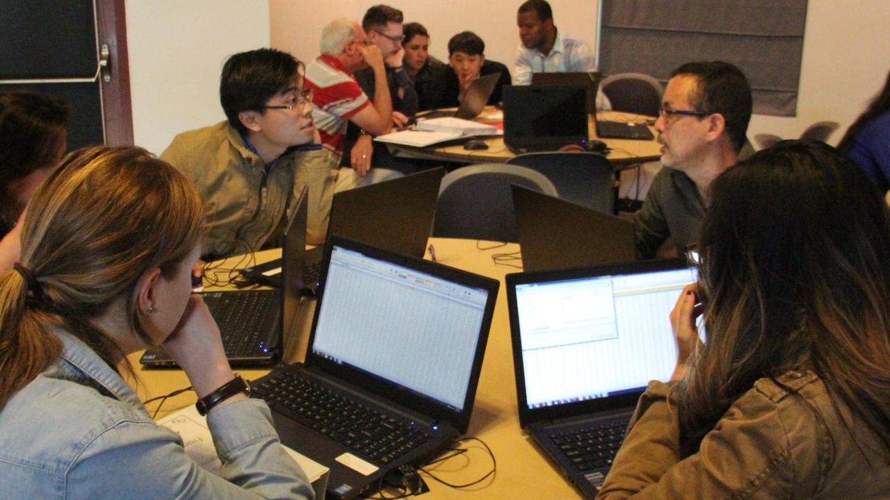 Group of people working around on laptops.