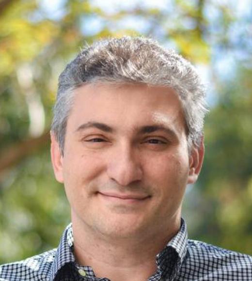 A person smiling for a picture. Picture of Professor Ilias Tagkopoulos.
